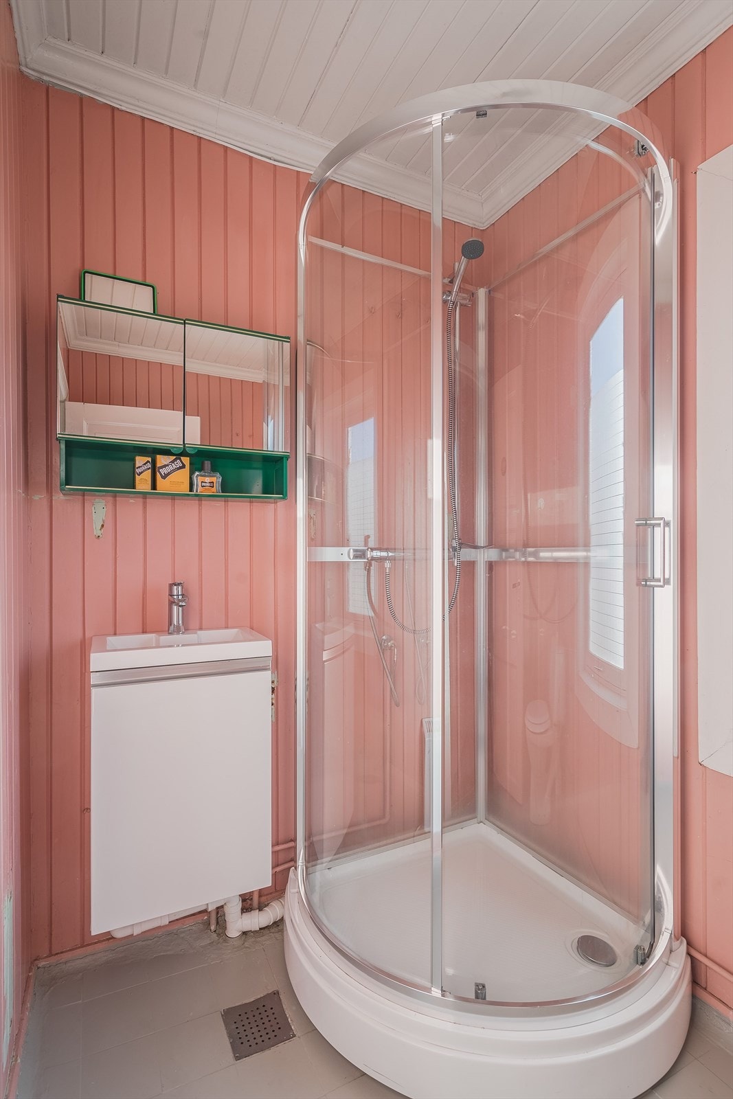 Eldre baderom i 2. etasje med fliser på gulv og overflater med malt panel. Montert dusjkabinett i 2019 som hindrer direkte vannsprut på overflatene, men baderommet må oppgraderes for å tåle normal bruk etter dagens krav. Galleribilde