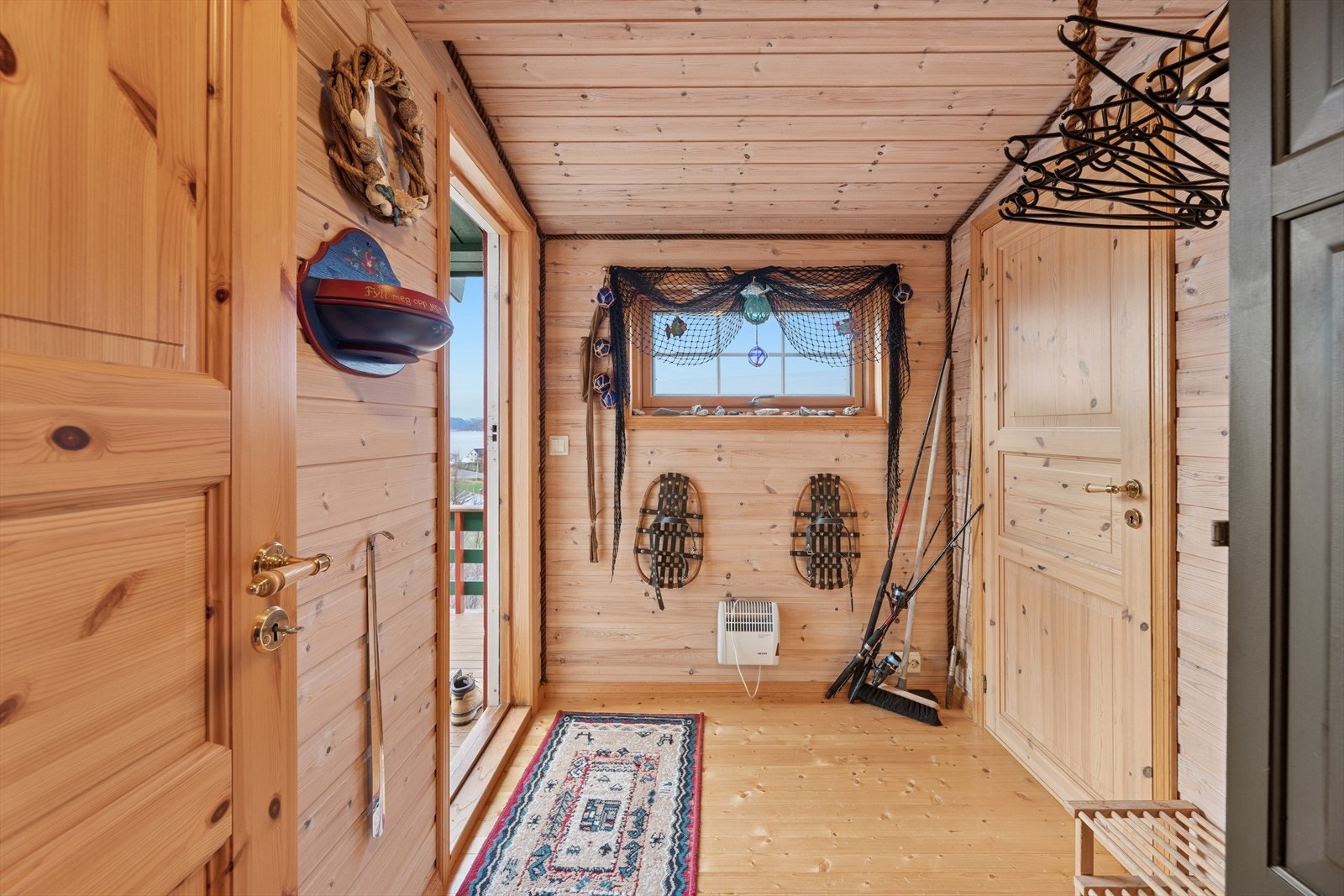 En lys og innbydende entré ønsker deg velkommen inn i hytta. Her får du god plass til å henge fra deg yttertøy og plassere fottøy. Galleribilde
