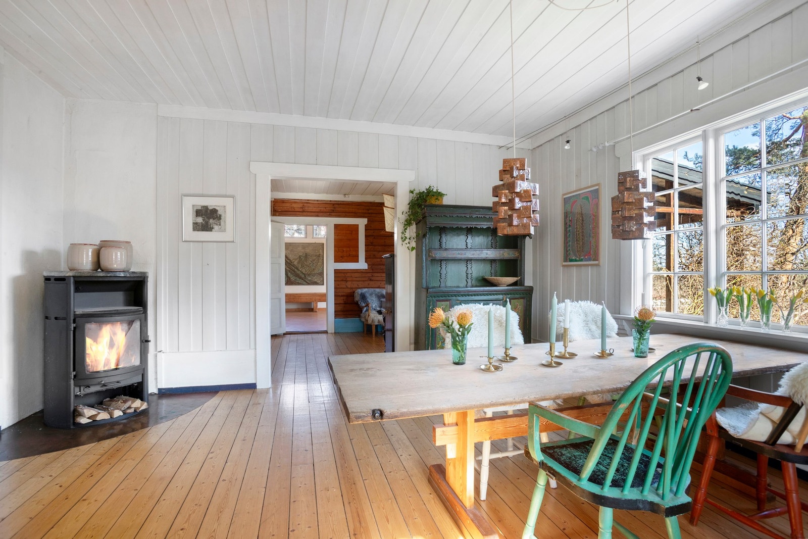 Spisestuen har det orginale tregulvet og malt panel på veggene. Nyere peisovn med klebersteinsplate. Galleribilde