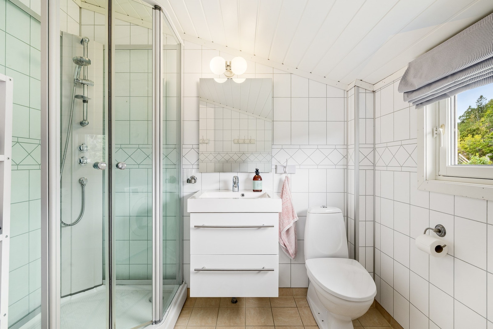 Badet har servant med skuffeseksjon under, wc, dusjkabinett og opplegg til vaskemaskin. Galleribilde