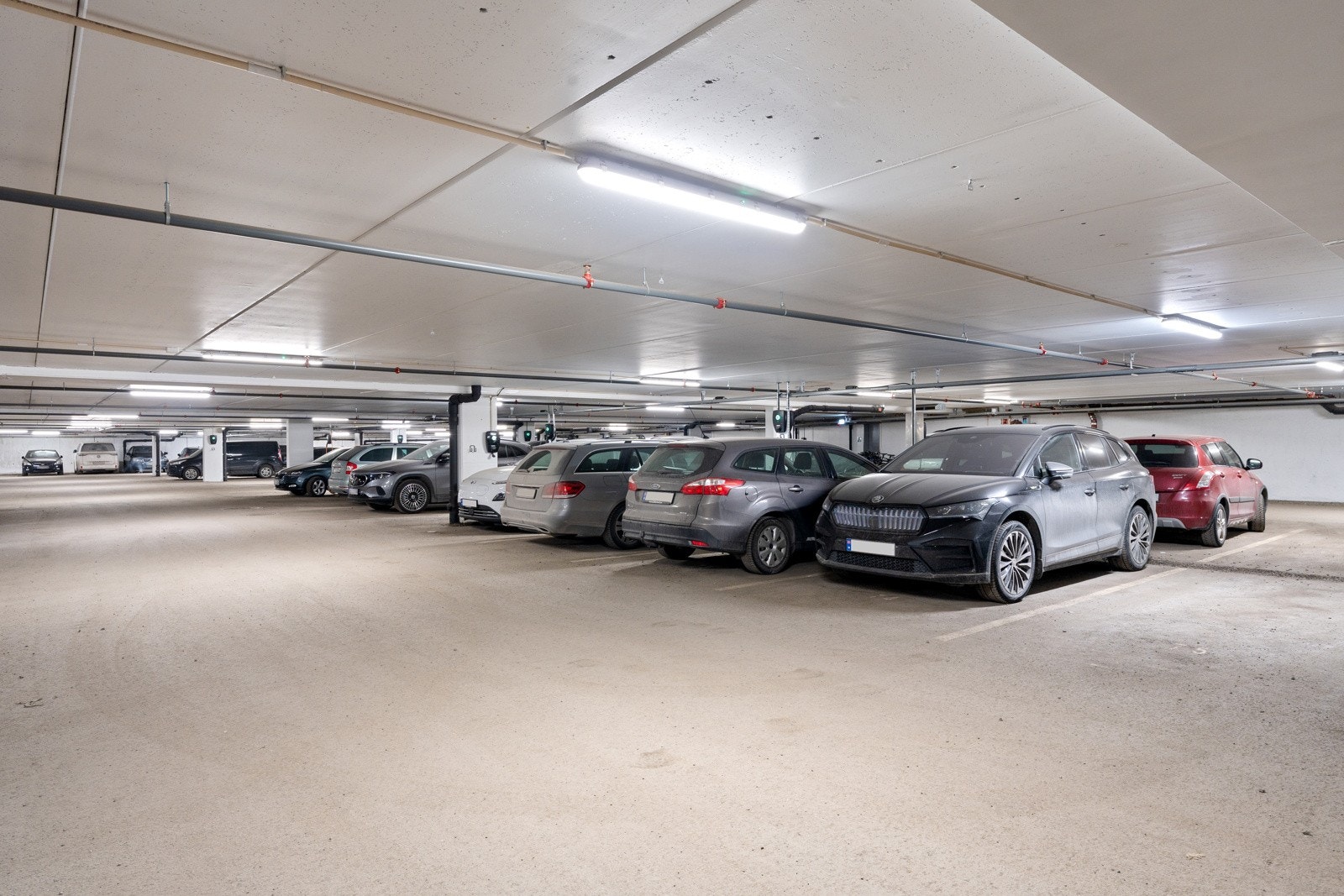 Parkering i lukket garasjeanlegg. Én fast oppstillingsplass medfølger leiligheten. Det er tilrettelagt for etablering av elbil lader i garasjeanlegget.