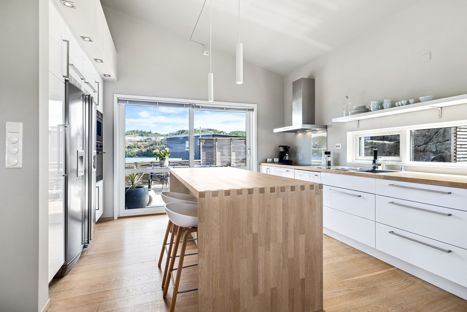 Lyst og moderne kjøkken med stor skyvedør ut til terrassen. Terrassen blir en naturlig kjøkkenforlenger på sommeren. Kjøkkenet har perfekte løsninger for både matlaging og sosiale sammenkomster. Galleribilde