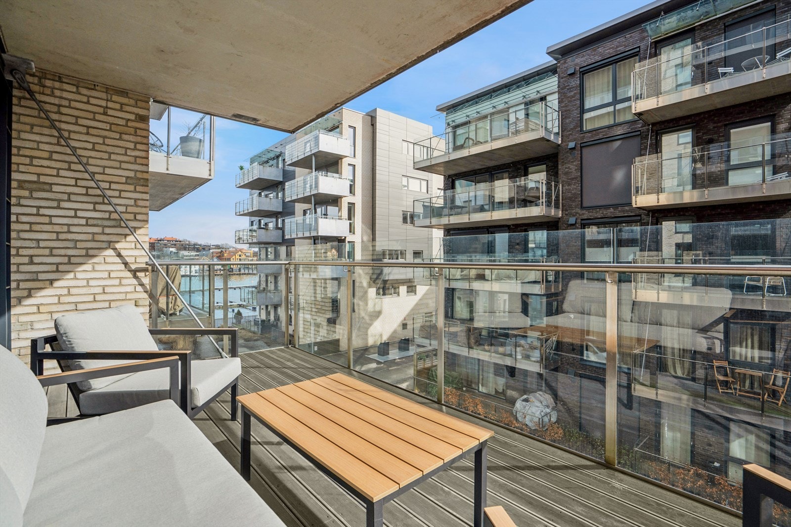 Balkongen er takoverbygget fra leiligheten over, og pent innrammet med rekkverk i glass. Galleribilde