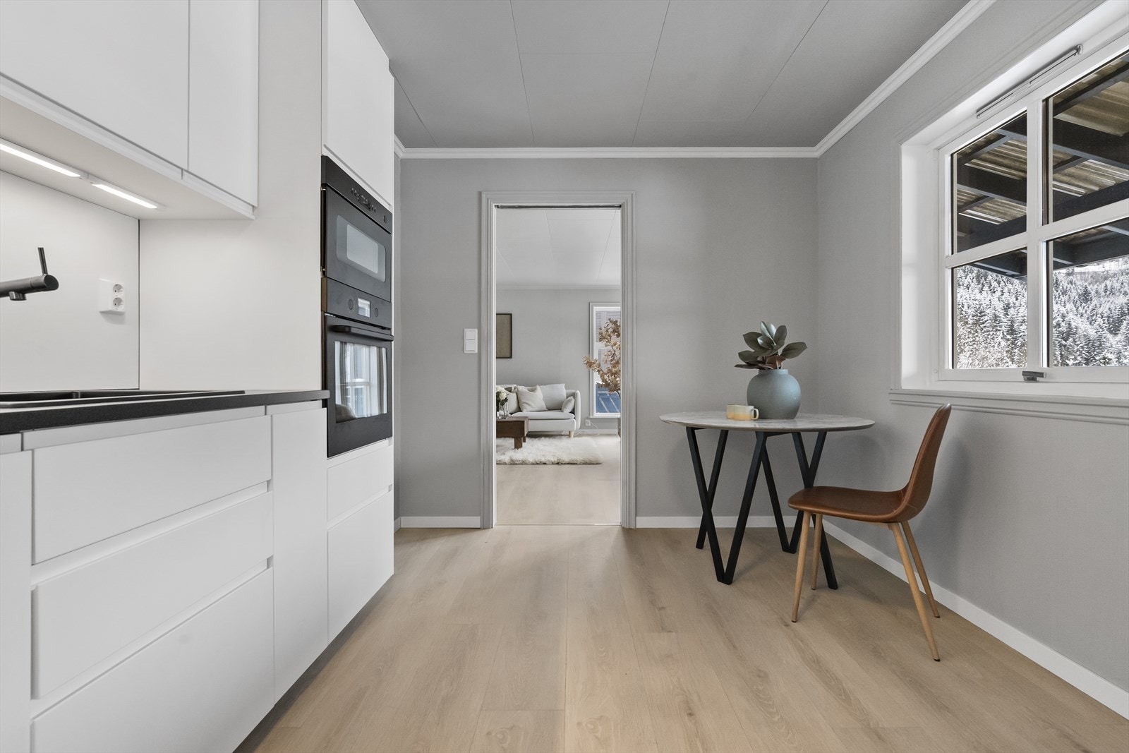 Ei praktisk skyvedør med glas skil kjøkkenet frå stova, og skaper ei fleksibel planløysing. Galleribilde