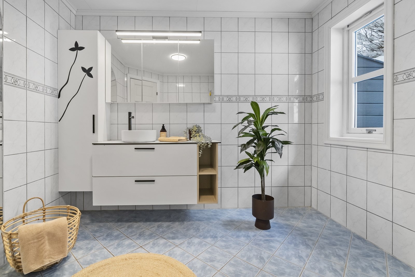 Baderomsinnreiing med laminatbenkeplate, servantskål, høgskap og overskap med speildører. Galleribilde