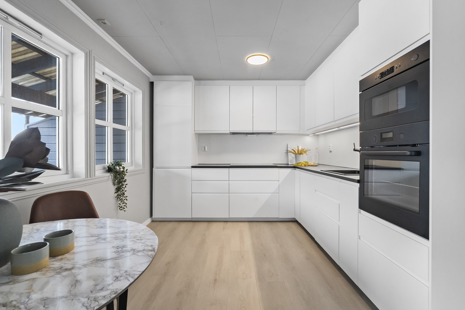 Nytt Ikea-kjøkken frå 2025 med kvite, slette frontar og laminatbenkeplater. Galleribilde