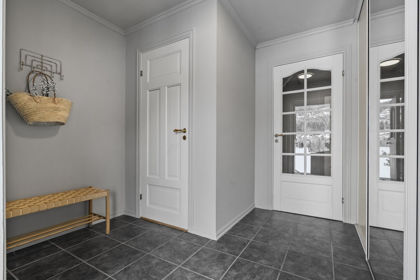 Vindfanget har også takhøg skyvedørsgarderobe og praktisk oppbevaringskott bak døra til venstre. Galleribilde