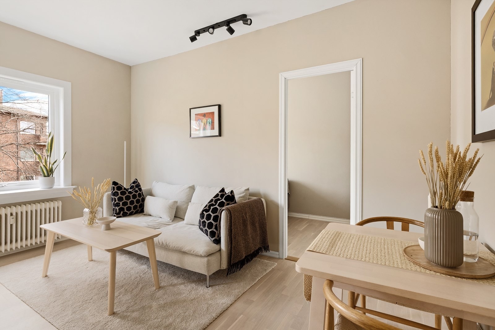 Velkommen til Drammensveien 119! Stue med lysmalte vegger, parkettgulv og plass til sittegruppe ved vinduet. Foto: Stian Frøysang Galleribilde