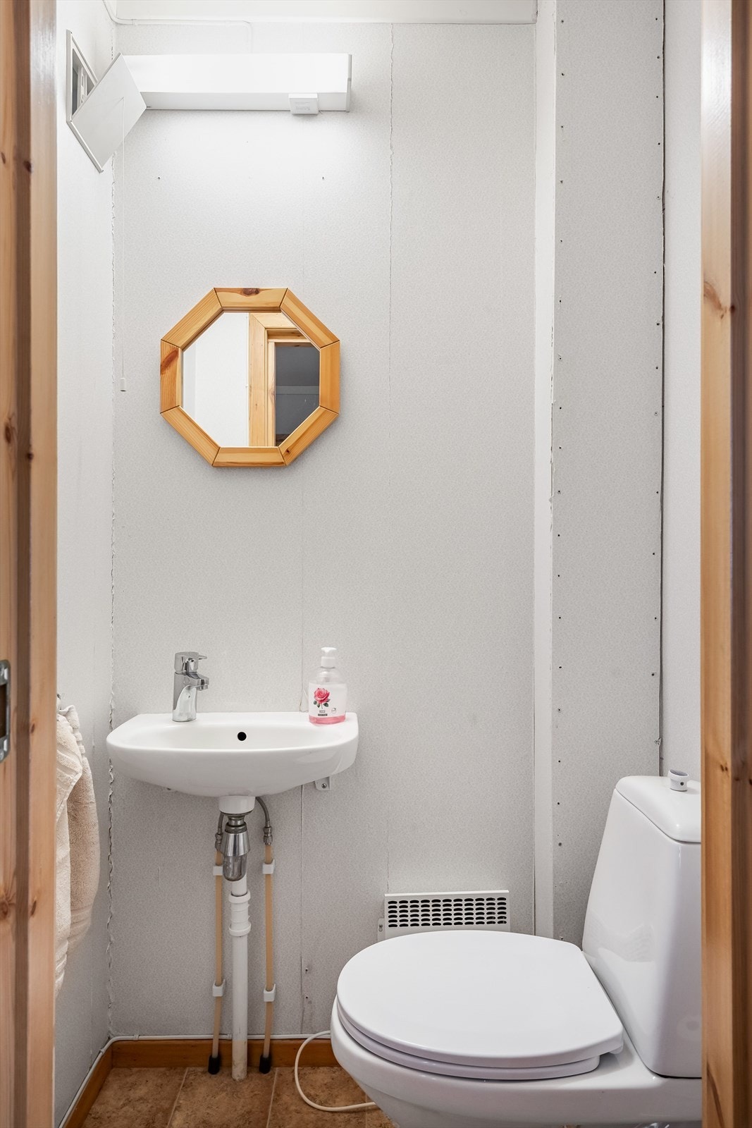 Toalettrom i 1. etasje med adkomst fra entréen. Gulvbelegg og tapet, samt innredning med toalett og servant. Galleribilde