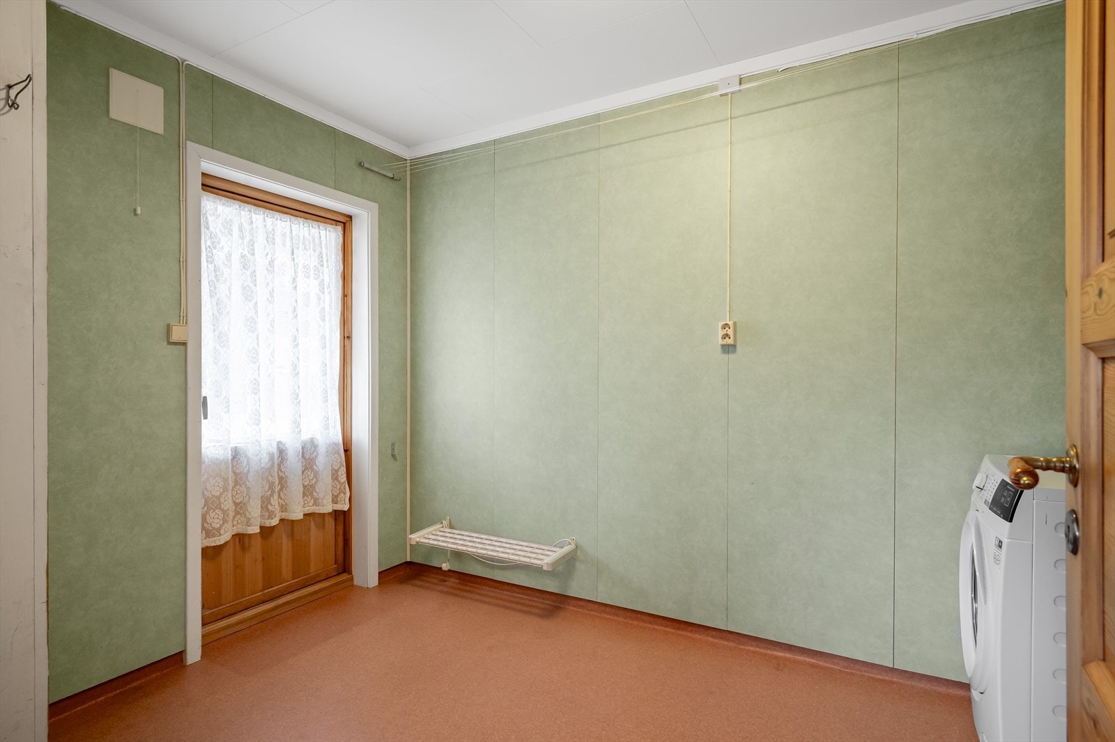 Vaskerommet har baderomsplater på veggene, vinylbelegg med oppbrett på gulv, naturlig ventilasjon og direkte adkomst ut. Galleribilde