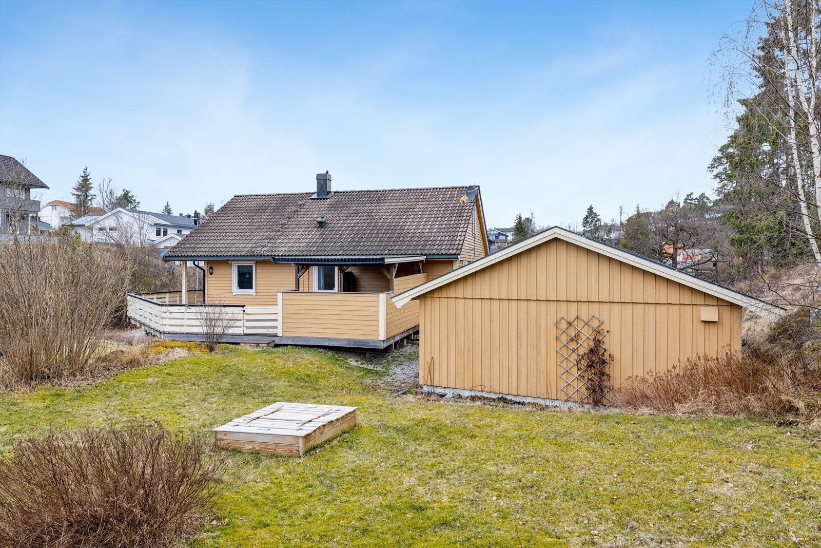 Tomten er lett skrånende med en kombinasjon av opparbeidet hage og naturlig terreng med fjell i dagen. Galleribilde