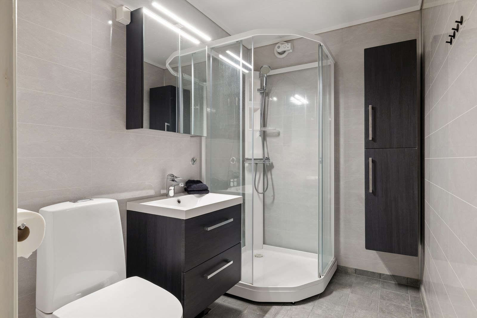 Badet i underetasjen er praktisk innredet med dusjkabinett, servantskap og toalett. Galleribilde