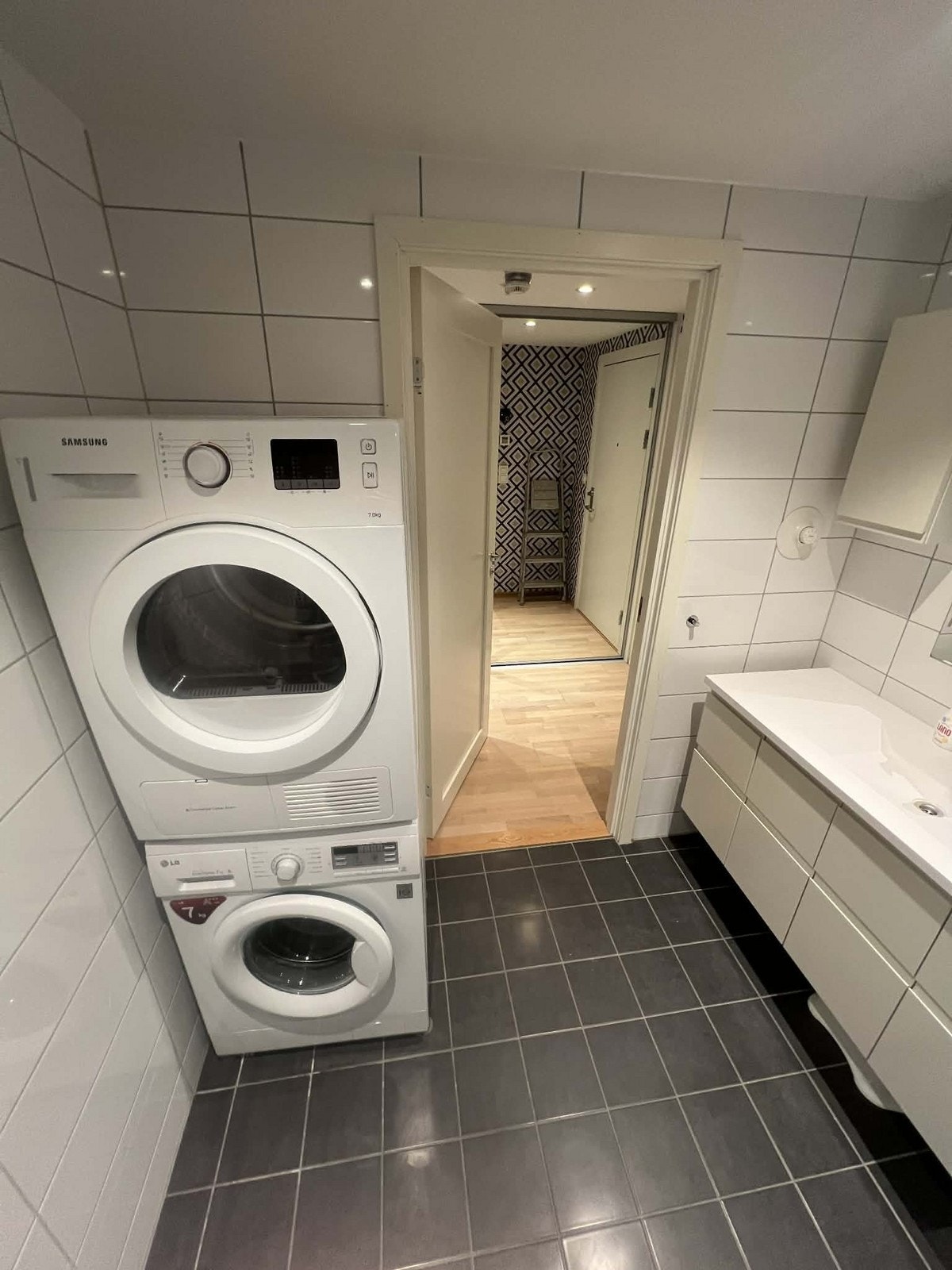 Badet er helflise og inneholder tørketrommel og vaskemaskin Galleribilde