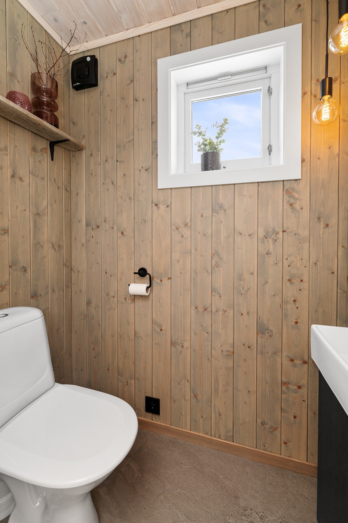 Toalettrommet har flislagt gulv og vegger samt himling kledd med trepanel, som gir et lunt og helhetlig uttrykk. Galleribilde