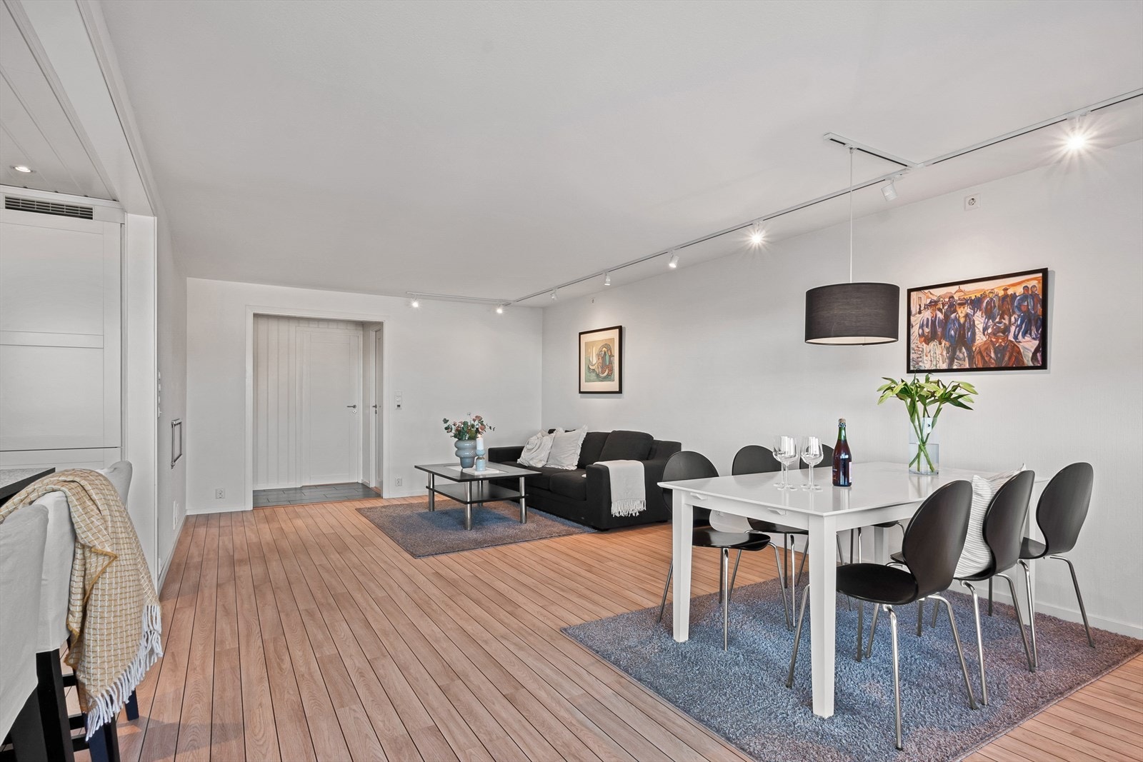 Stuen er romslig med god plass til sofaløsning og spisestue. Spotteskinner fra vegg til vegg sørger for god belysning. Galleribilde