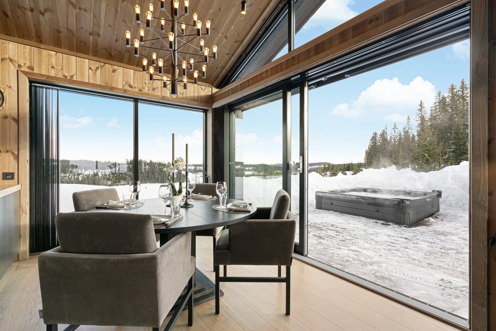 Stuen m/store vindusflater fra gulv til tak. NB! Bildet er hentet fra tilsvarende fritidsbolig i prosjektet. Utsynet vil variere noe grunnet tomtens plassering. Jacuzzi medfølger ikke. Galleribilde