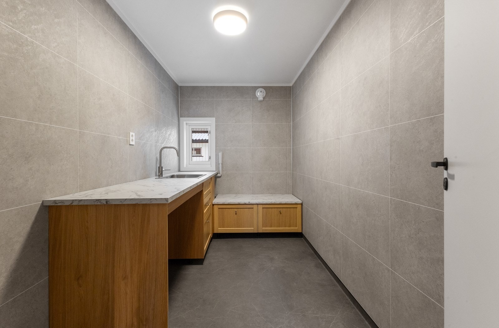 Hva med et helt separat og eget vaskerom? Dette ligger vis-a-vis hall og rett ved entre. Dette er helt nytt og ubrukt. Meget praktisk innredet og pent materialvalg selvsagt. Galleribilde