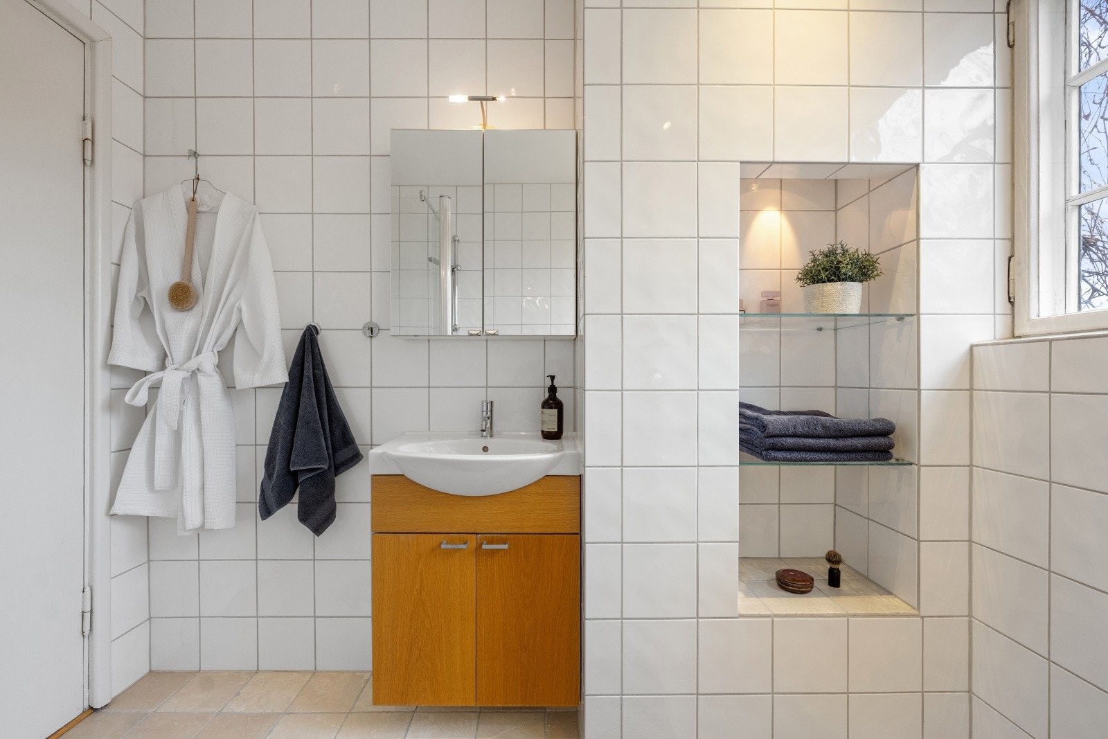 Badet er innredet med servant og har praktiske, innfelte hyller. Galleribilde