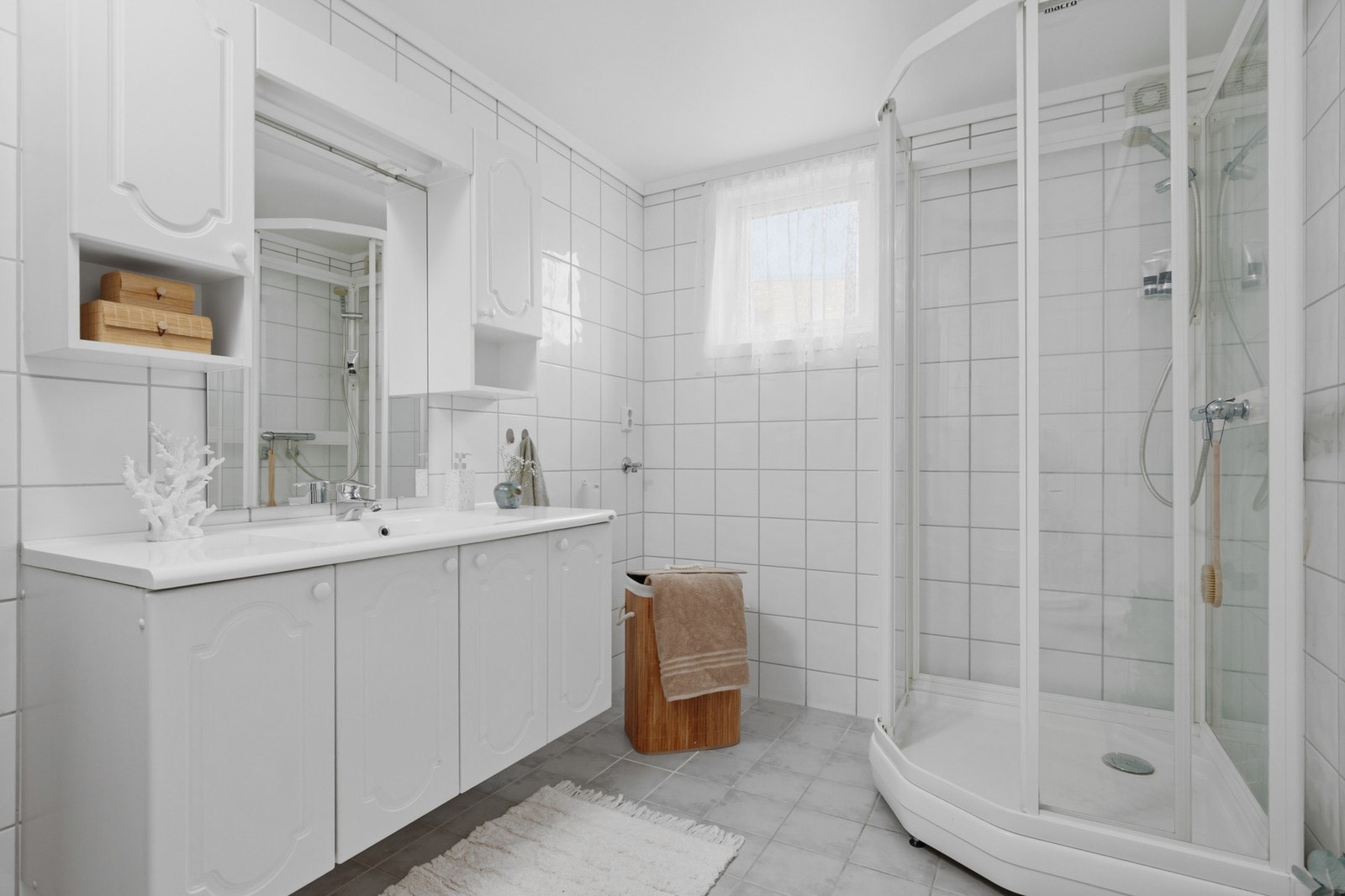 Badet er flislagt og utstyrt med varmekabler, dusjkabinett og opplegg for vaskemaskin. Galleribilde
