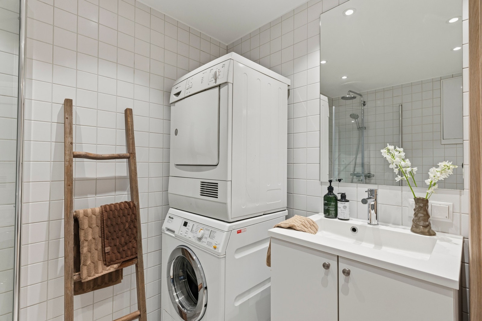 Opplegg for vaskemaskin og tørketrommel, noe som gjør badet praktisk og godt tilrettelagt for hverdagens behov. Galleribilde