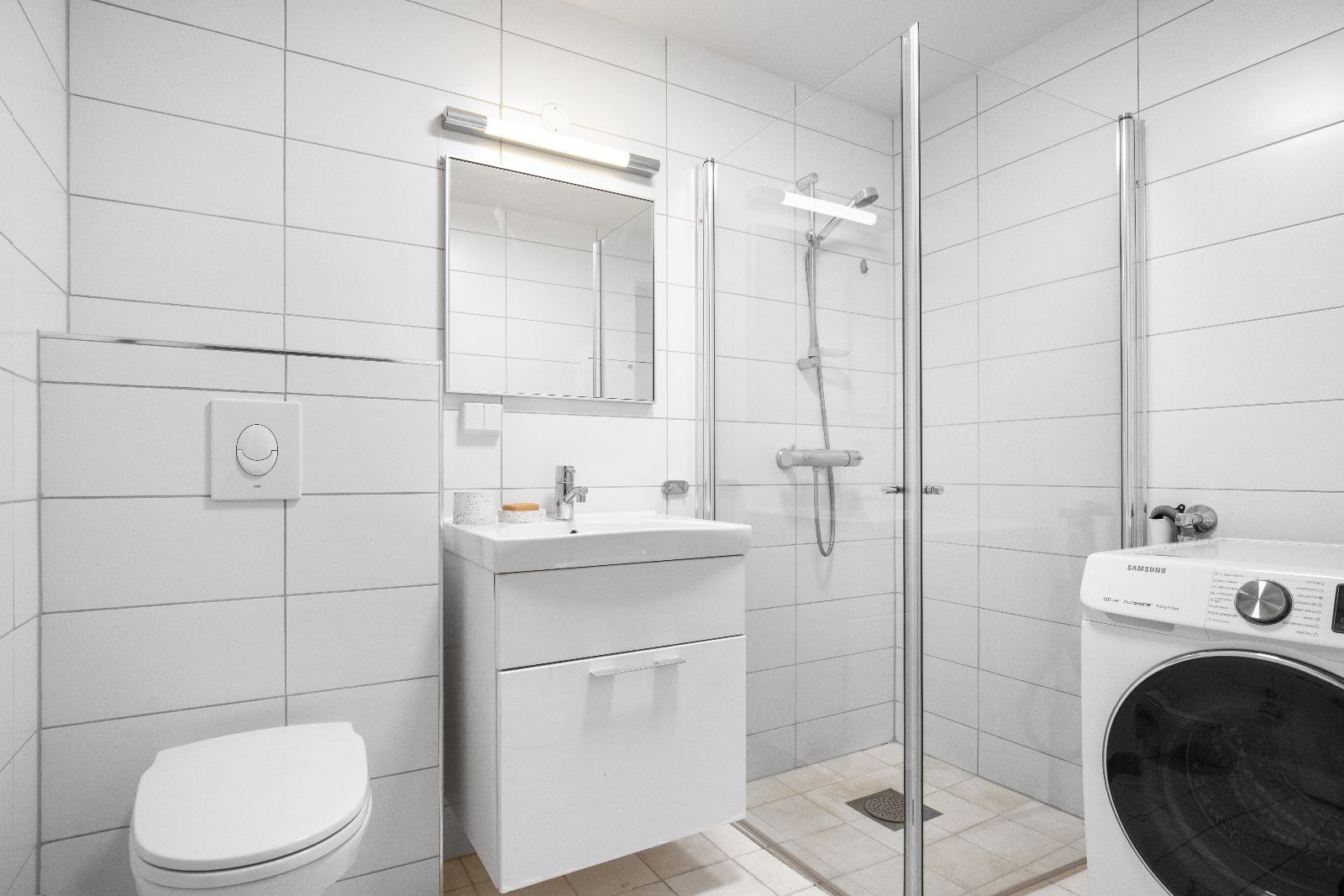 Flislagt bad med varmekabler i gulv og vaskemaskin. Galleribilde