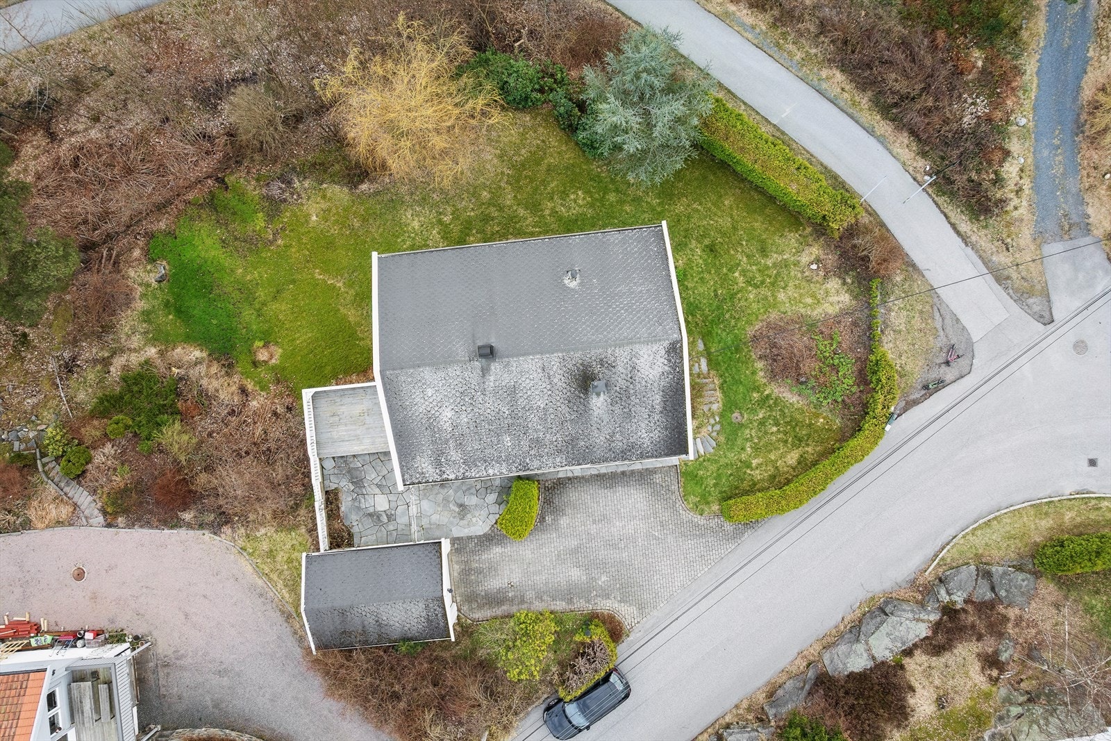 Tomten er oversiktlig og velutnyttet, med belegningsstein på gårdsplassen. Galleribilde