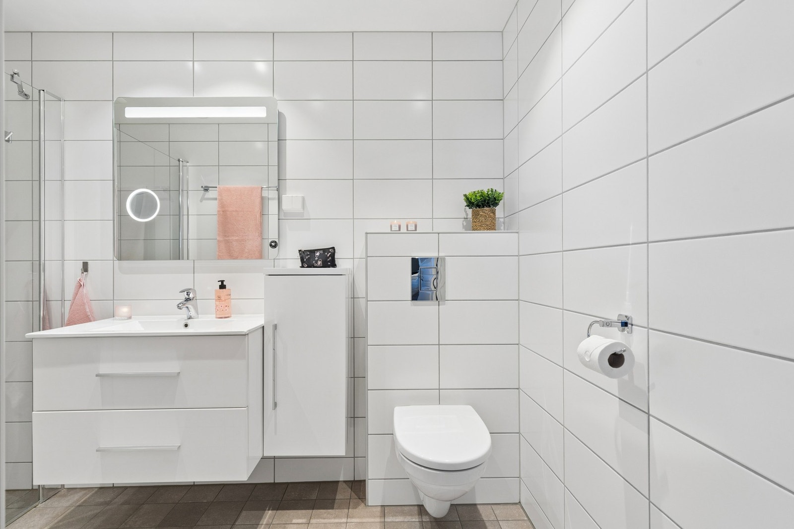 Pent og moderne flislagt bad i lyst design. Flislagt gulv med gulvvarme. Galleribilde