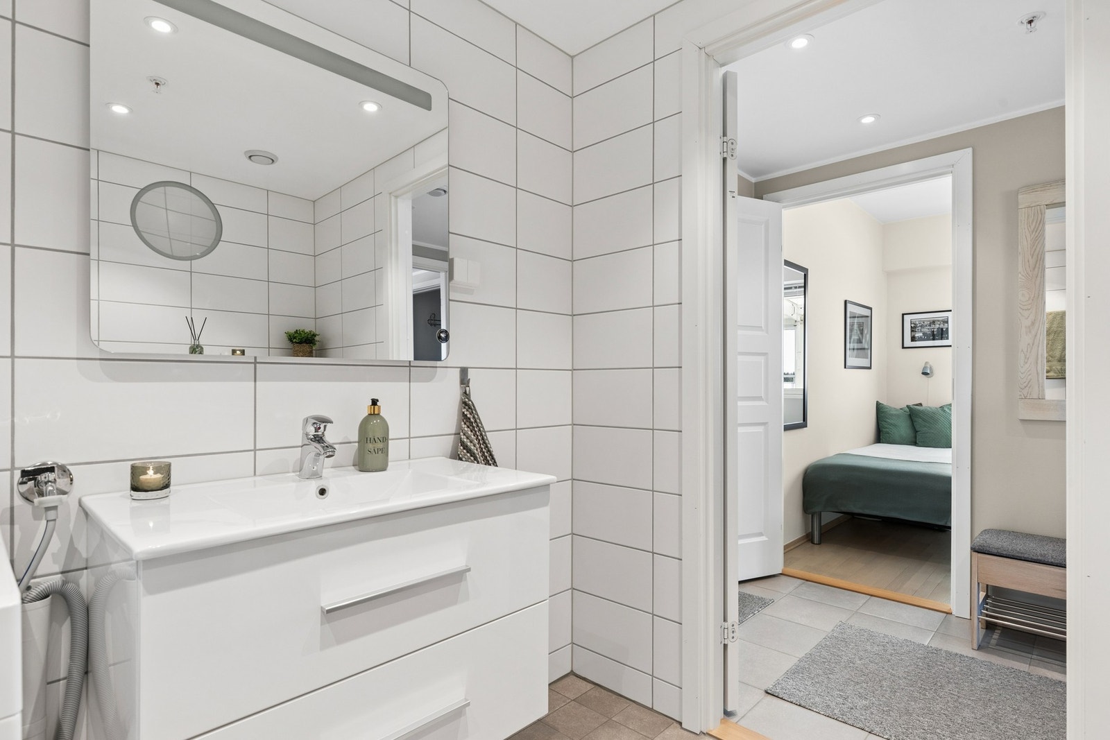 Pent og moderne flislat bad i lyst design. Flislagt gulv med gulvvarme. Galleribilde