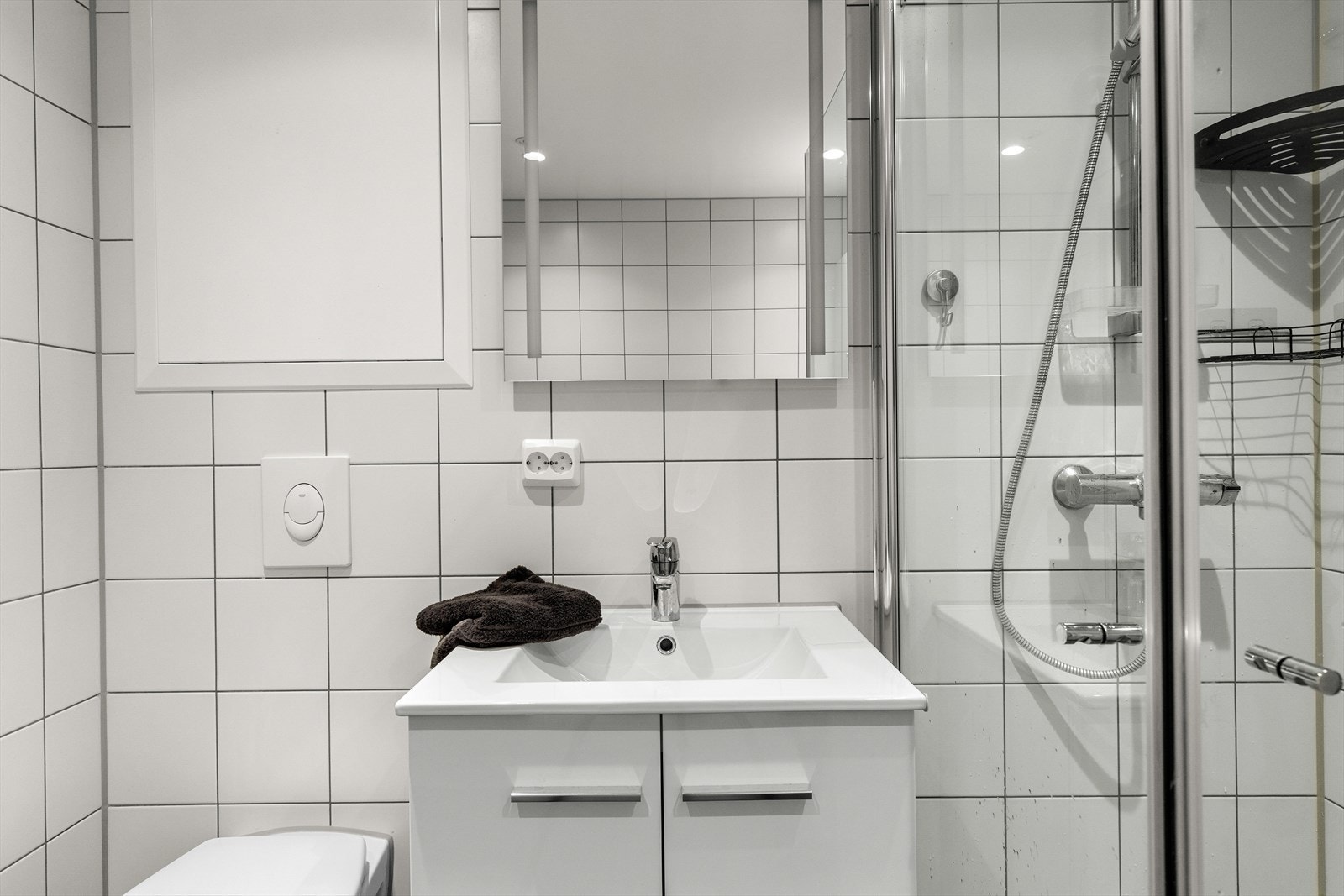 Badet er utstyrt med vegghengt toalett, hjørnedusj, baderomsinnredning og opplegg for vaskemaskin. Galleribilde