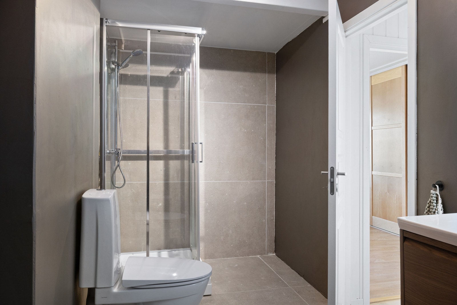 Badet ligger praktisk til i enden av gangen. Badet har nye fliser og dusjkabinett er av nyere dato i 2026. Galleribilde