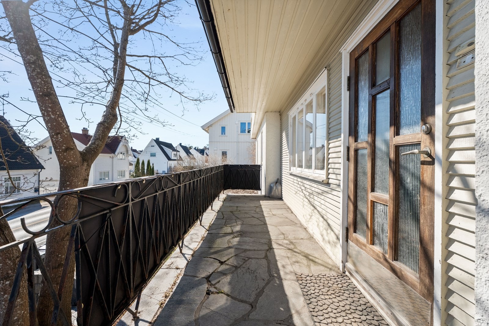Inngangsterrassen på ca. 9 m² har skiferbelagt dekke og smijernsrekkverk. Galleribilde