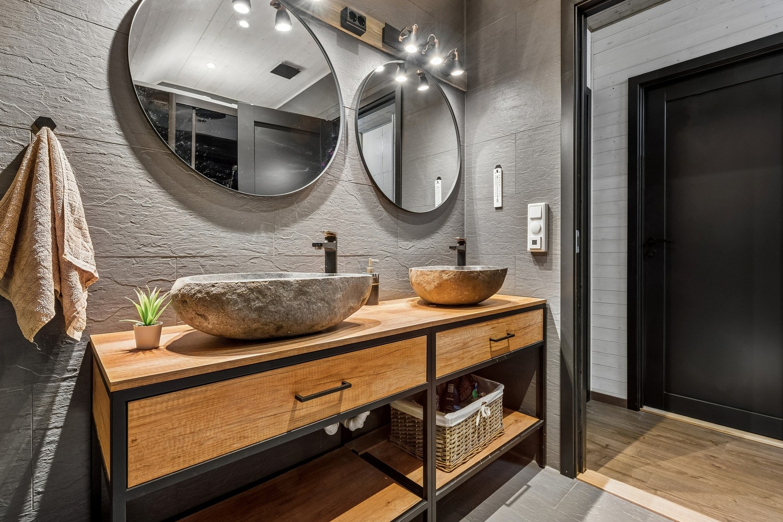 Badet er innredet med dobbel servant, veggmontert toalett og stort dusjkabinett. Galleribilde