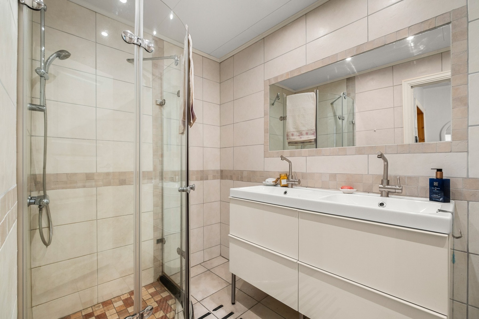 Badet er fra 2009 og er innredet med et dobbelservant, veggintegrert speil og dusjhjørnet Galleribilde