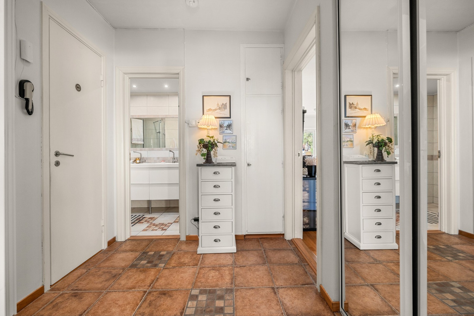 Romslig flislagt entrè med skyvedørsgarderobe og porttelefon Galleribilde