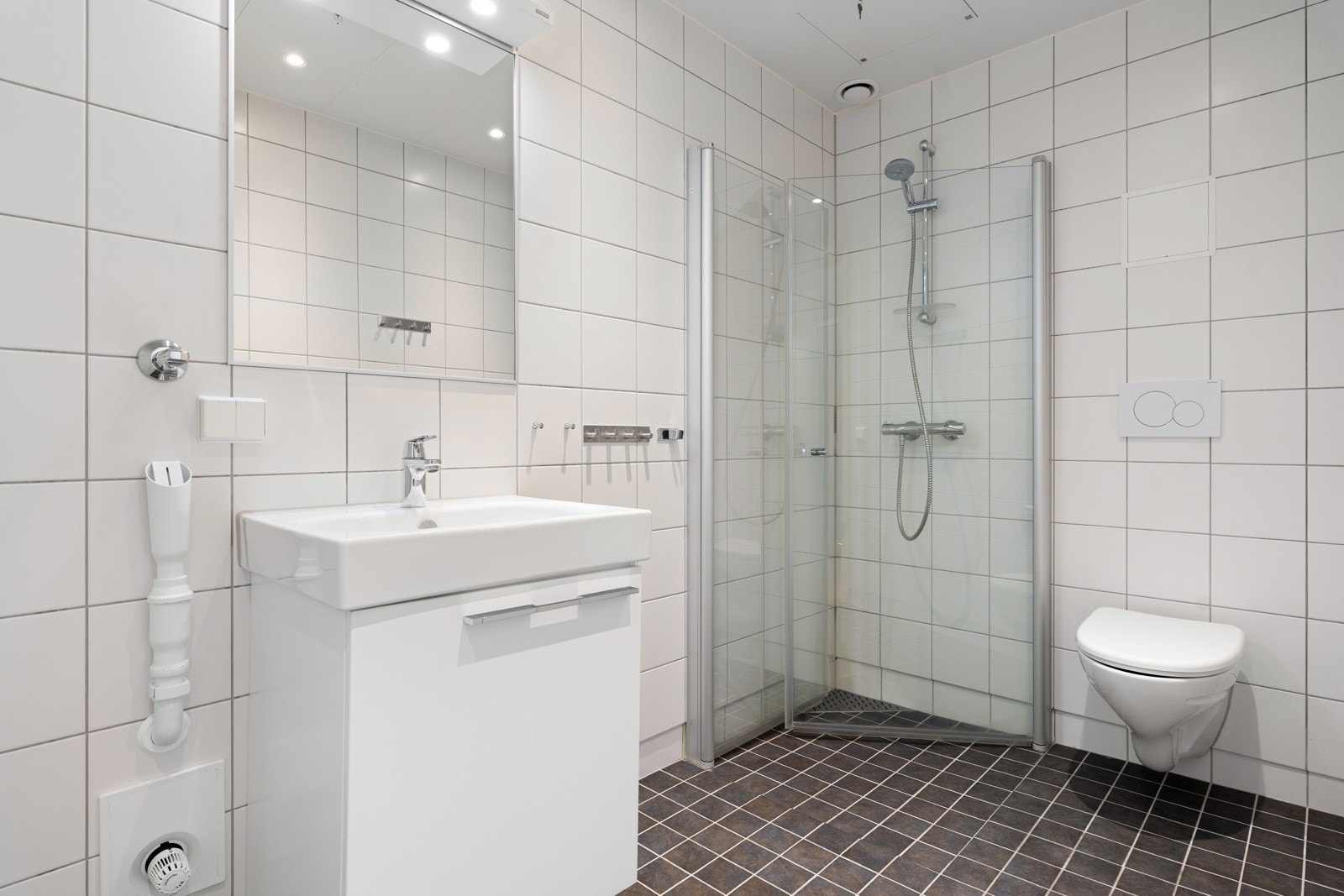 Tiltalende flislagt baderom med downlights og behangelig gulvvarme.