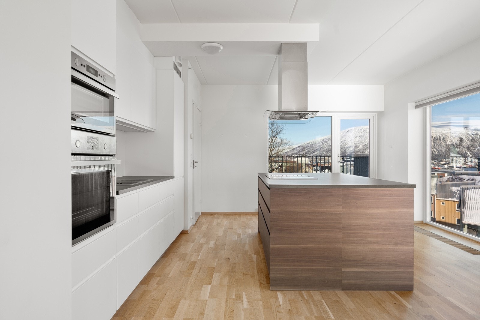 Delikat kjøkken med kjøkkenøy som både gir ekstra benkeplass og en naturlig sosial sone.