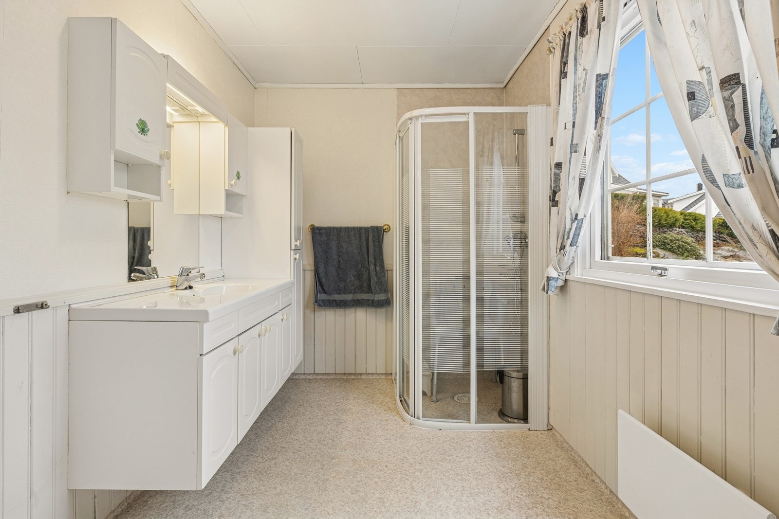 Lys og romslig baderomsinnredning med mye oppbevaringsplass for baderomsartikler. Galleribilde
