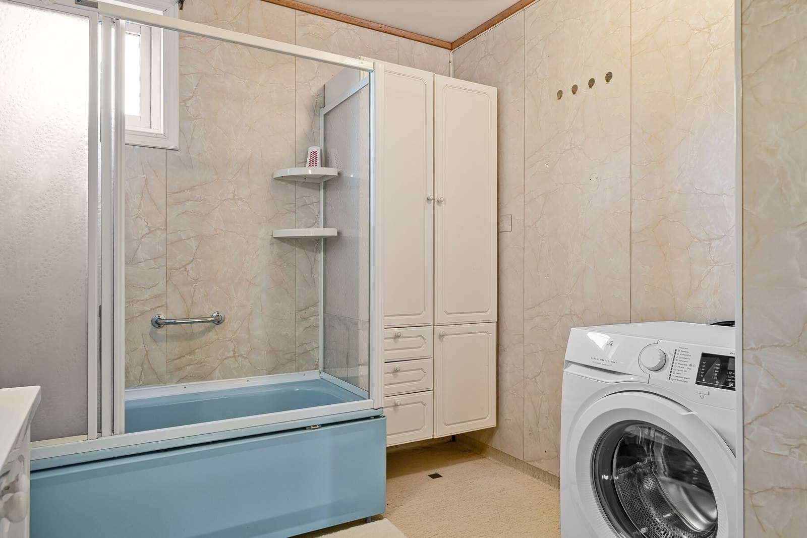 Badet er utstyrt med servant i innredning, toalett, badekar og opplegg for vaskemaskin Galleribilde