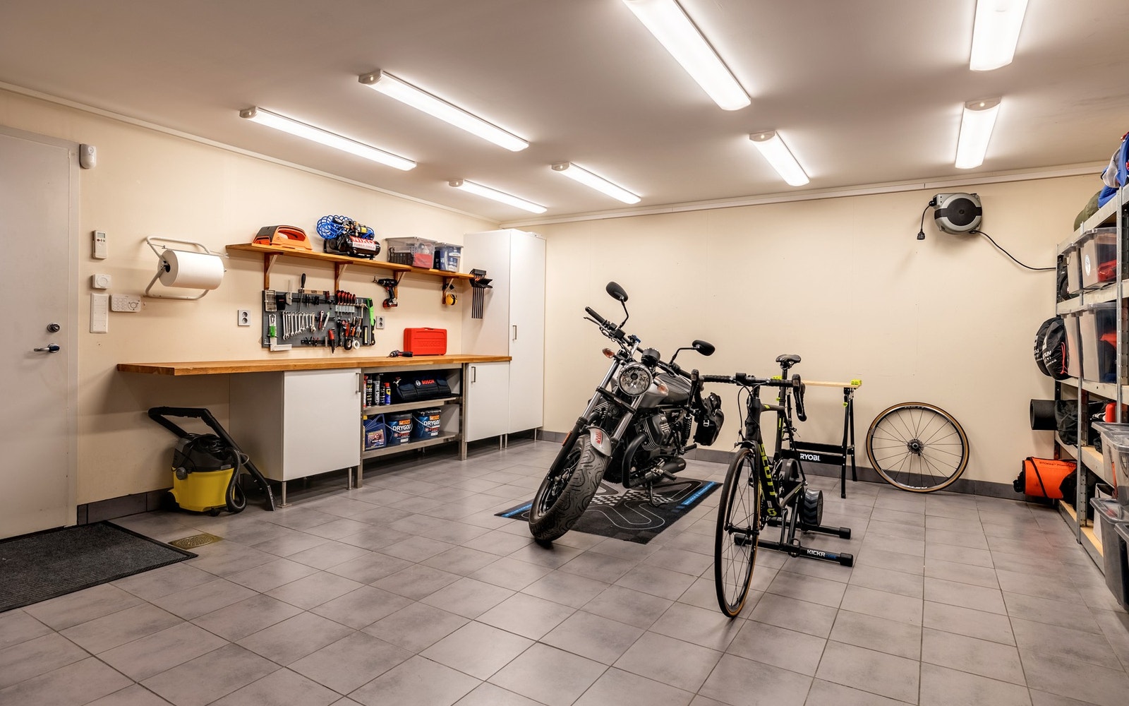 Stort verksted/bod med flislagt gulv med varmekabler og sluk. Galleribilde