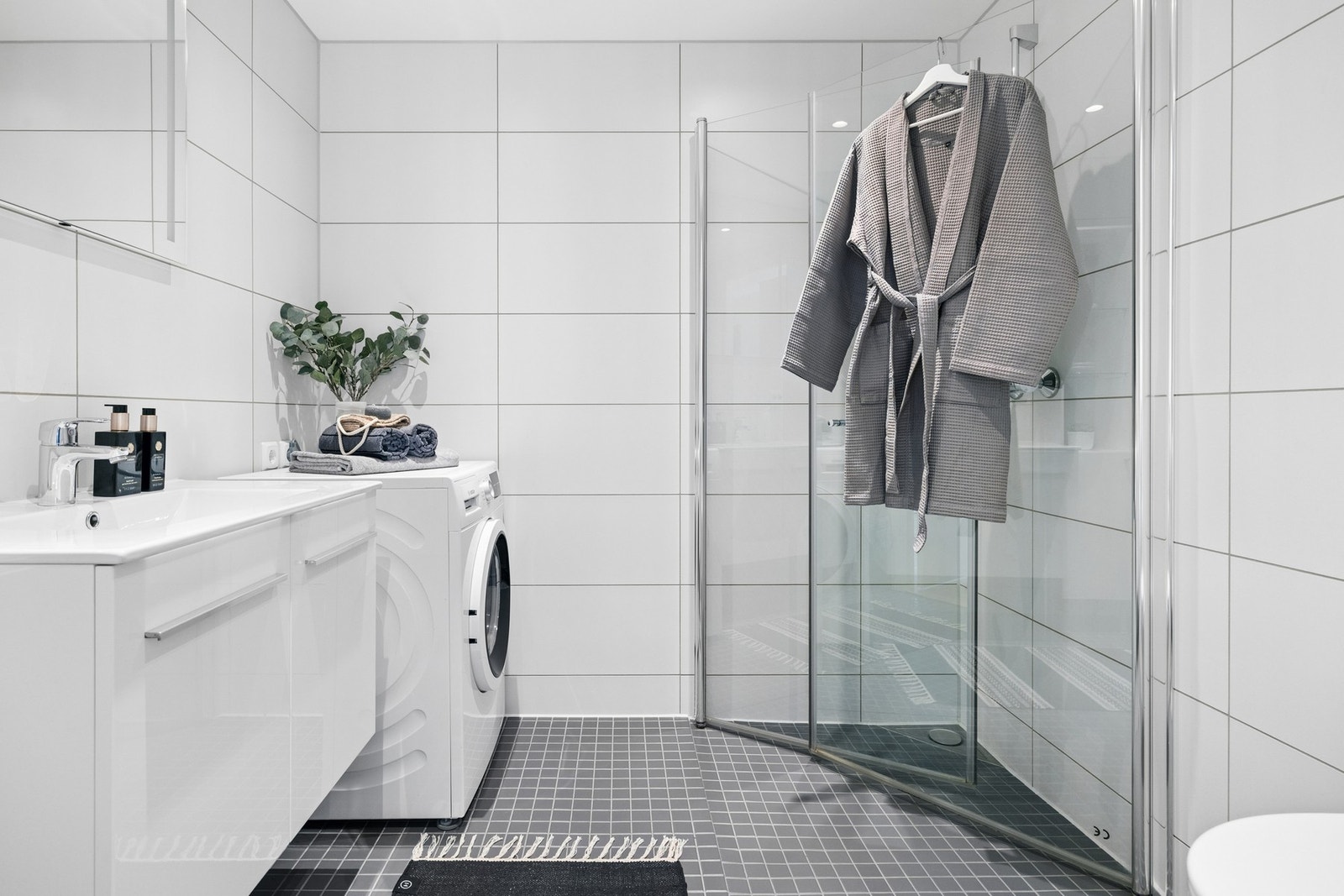 Strøkent og romslig bad på 4,3 m² med flislagte overflater og et moderne uttrykk. Galleribilde