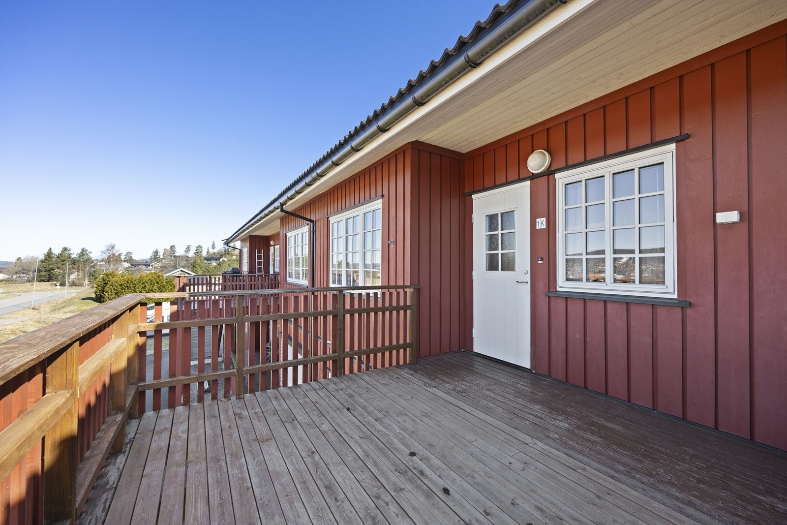 Det er trapp opp fra bakkeplan og fra verandaen som deles med naboen er det dør inn til leiligheten. Galleribilde