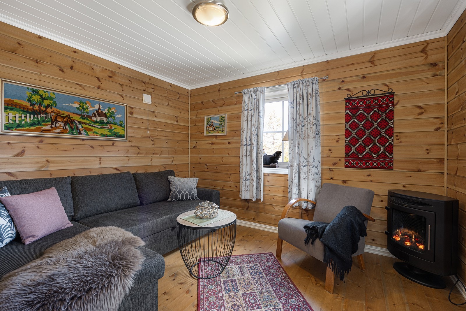 Rommene er innredet i samme stil som i hytta - liggende panel på veggene og originale heltregulv i oppholdsrommene. Galleribilde