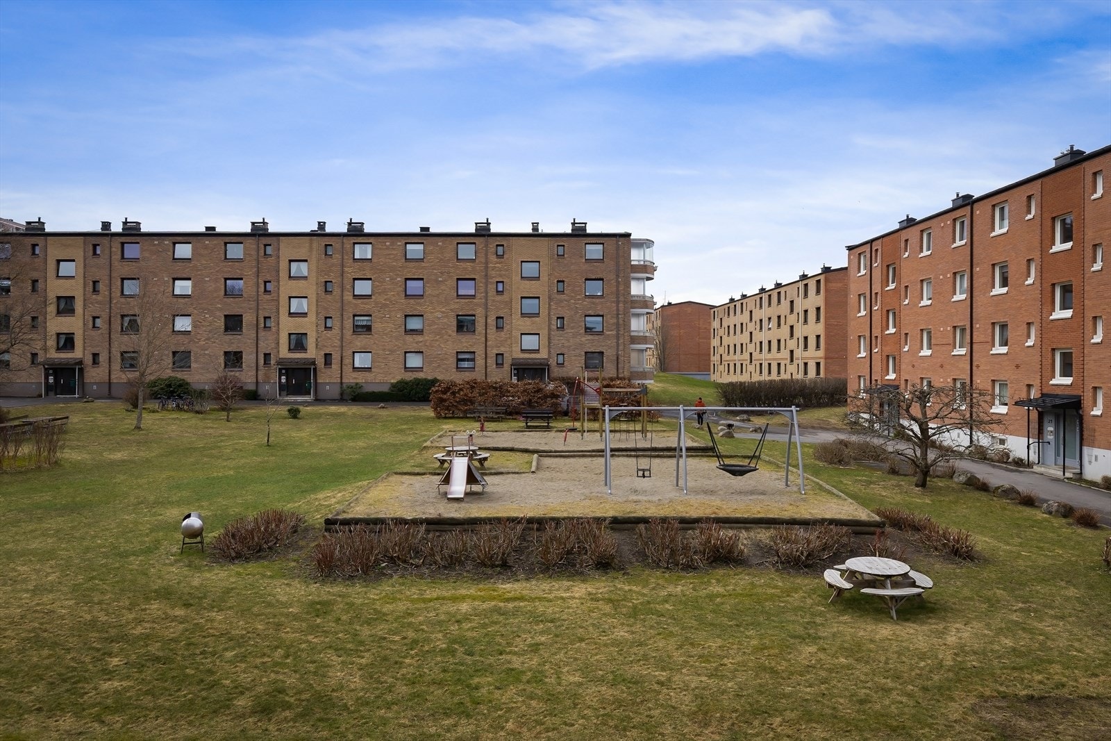 Fellesarealer med plen, beplantning, sittegrupper og lekearealer. Asfalterte gangstier. Galleribilde