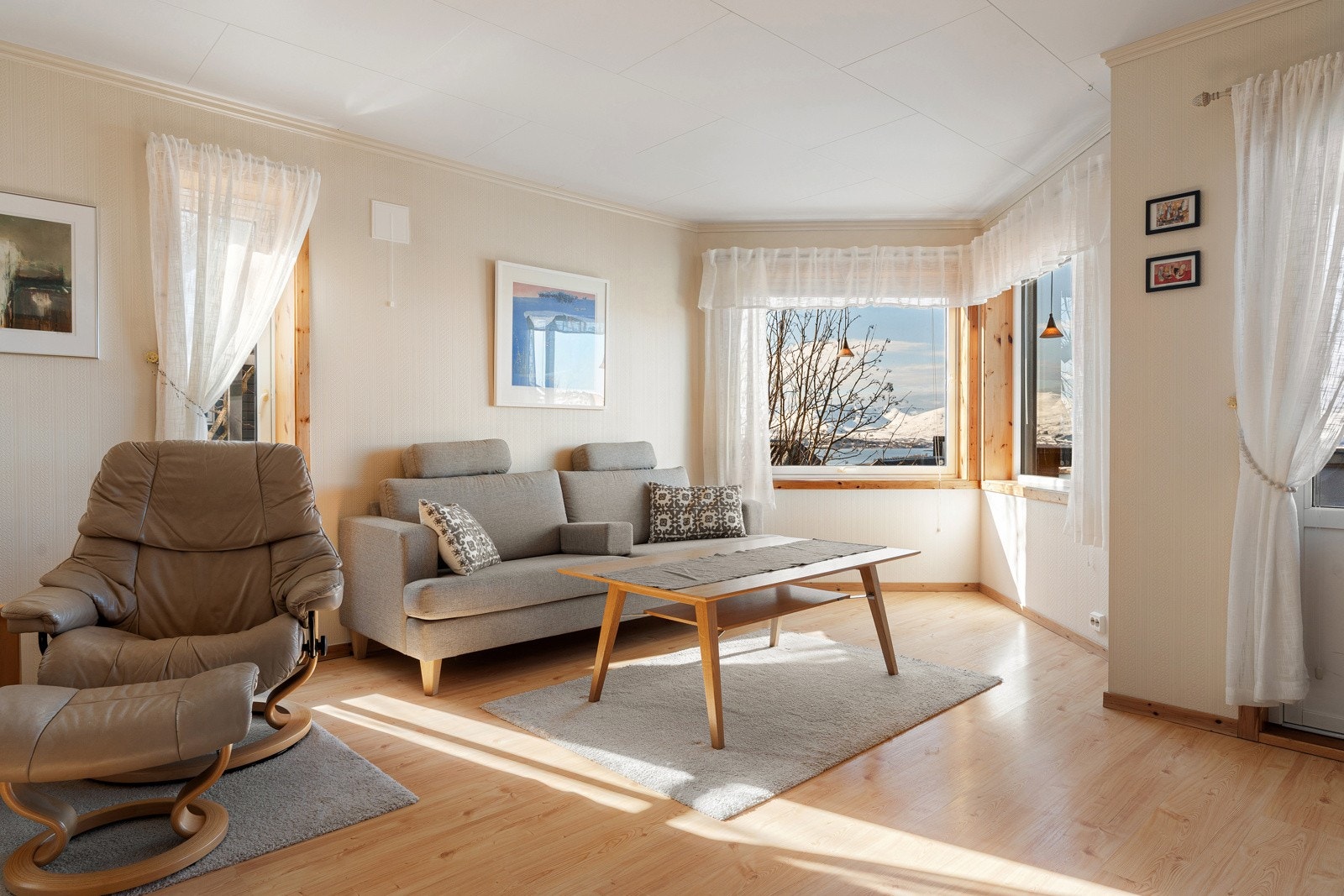 Stuen fremstår som lys og trivelig, og har malte veggoverflater og parkettgulv.