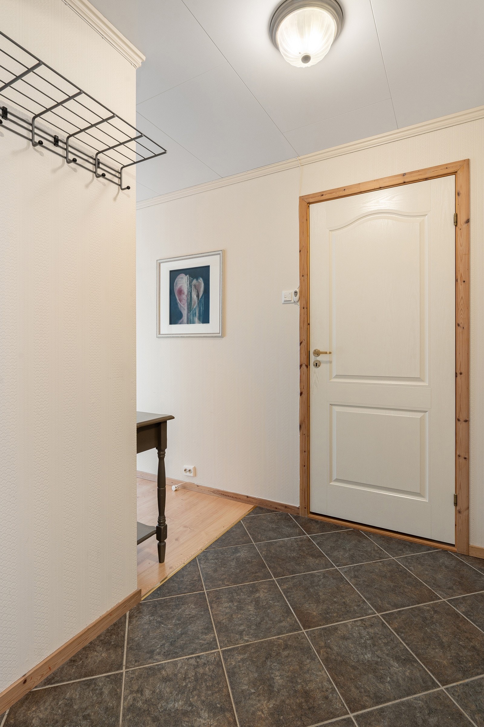 Entré med fliser på gulv, gulvvarme og plass til garderobeløsning.