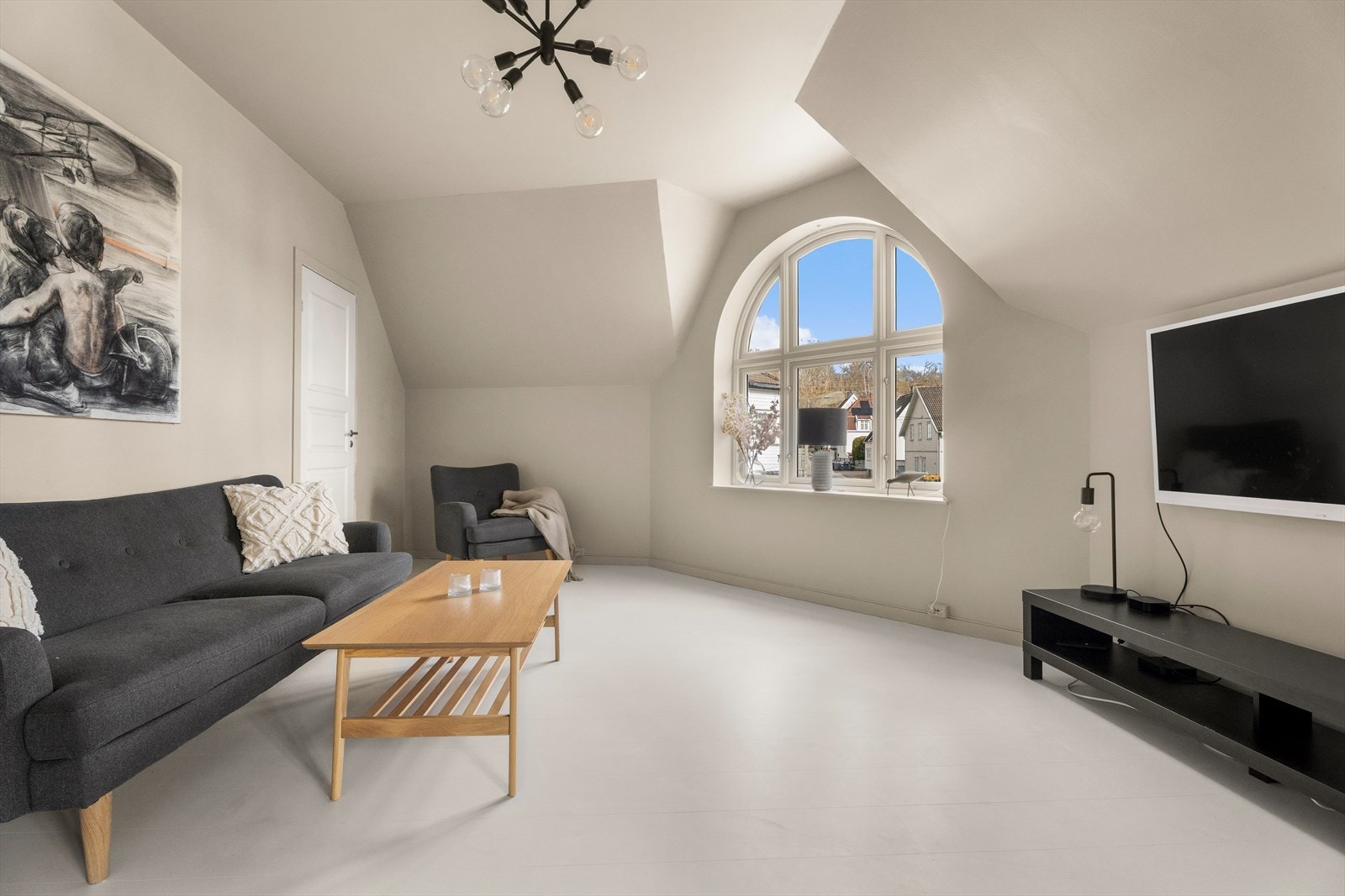 Stuen har god plass til sofagruppe. Skråtaket og de rene flatene gir rommet en moderne og lun atmosfære. Galleribilde