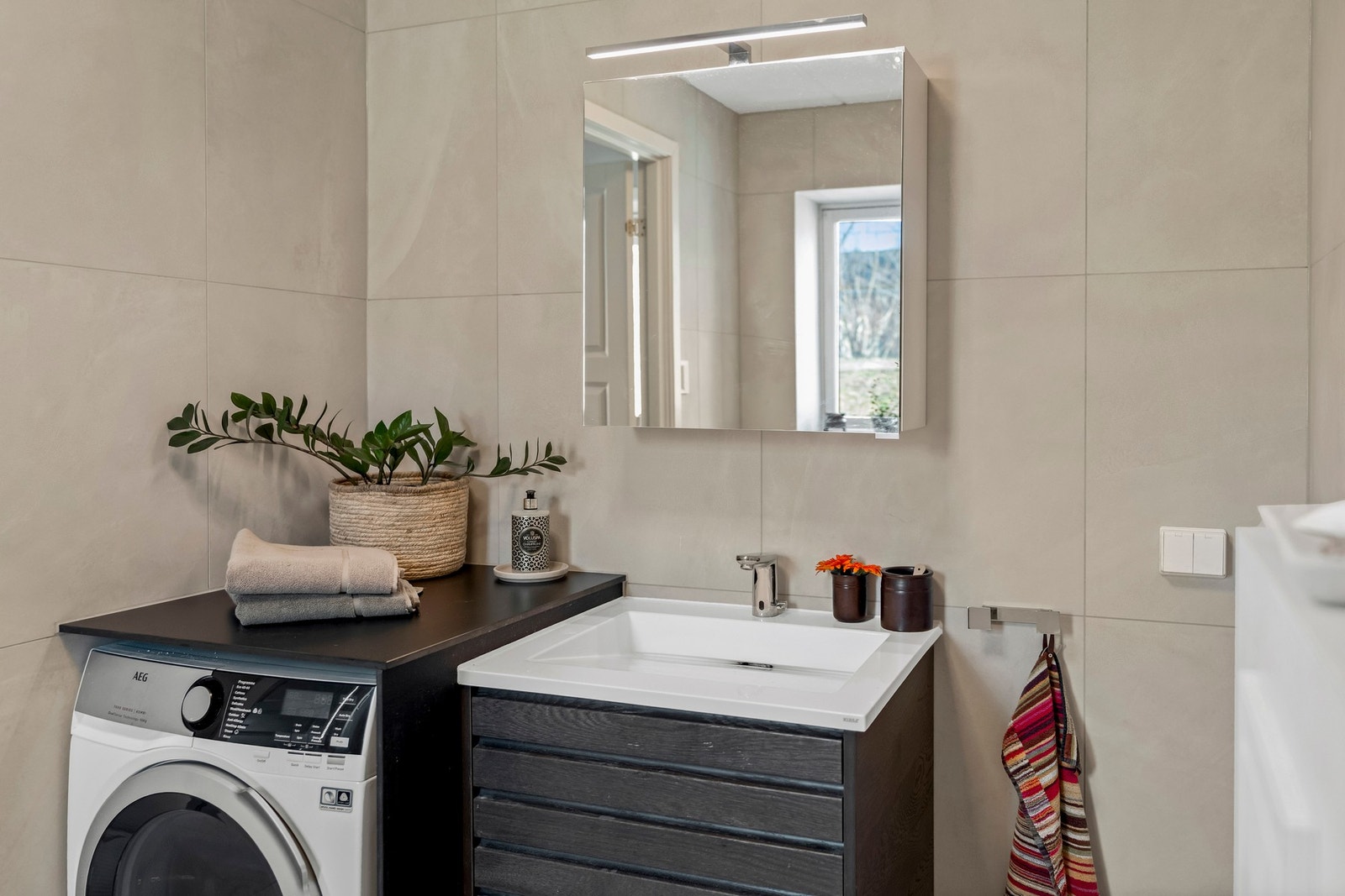 Badet er innredet med skapinnredning med nedfelt servant og berøringsfritt blandebatteri (sensor). Galleribilde