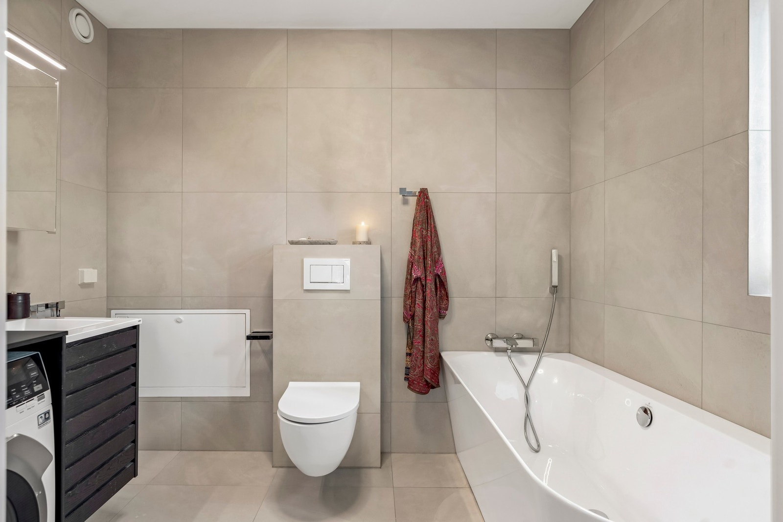 Veggmontert toalett og et stilig badekar i hovedbadet. Galleribilde
