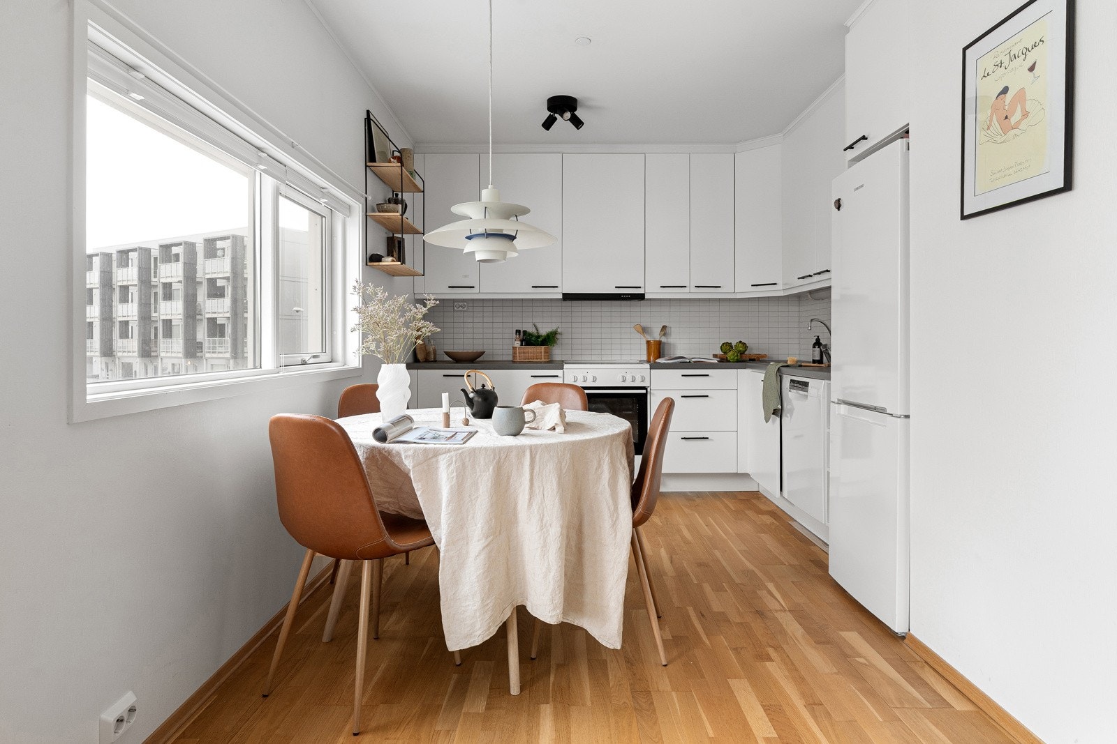 Praktisk kjøkkenløsning med plass til et koselig spisebord, som en naturlig avdeling mellom stue og kjøkken