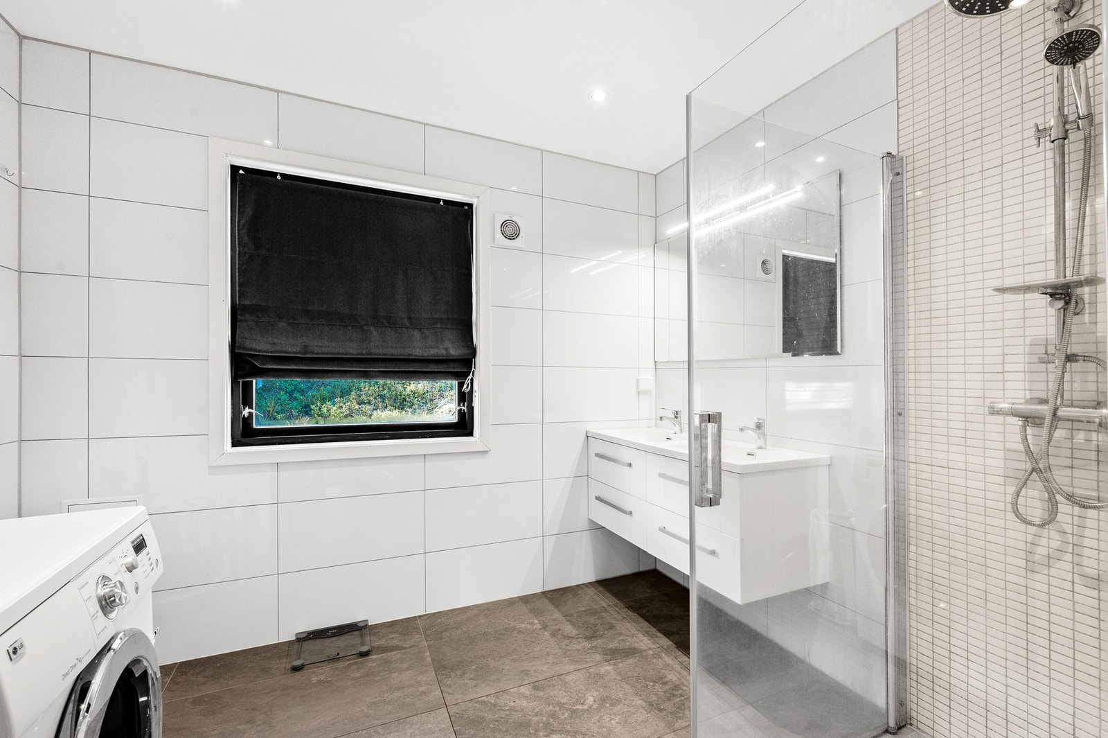 Badet i utleiedel 2 har varmekabler i gulv, opplegg for vaskemaskin og tørketrommel, dobbel servant med innredning og dusjhjørne med innfellbare glassdører. Galleribilde